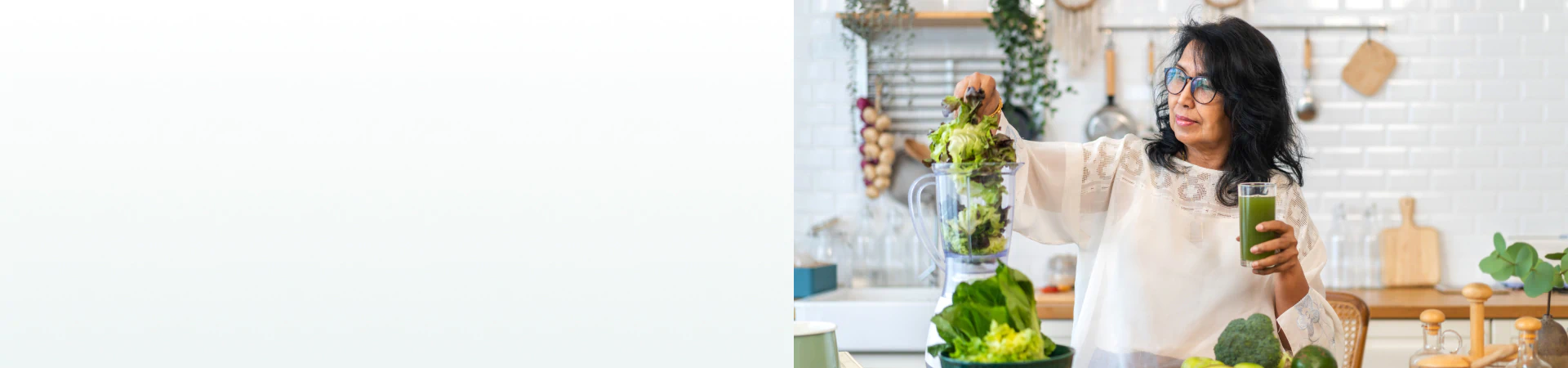 A woman in a kitchen blending leafy greens while holding a green juice, representing the benefits of supplements for cleanse and detox.
