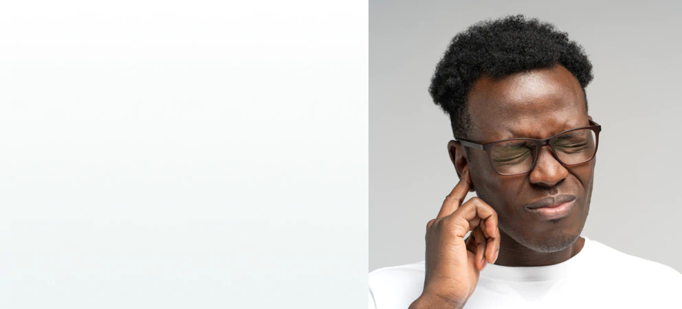 A man pressing his finger to his ear in discomfort, representing the need for supplements for hearing loss.