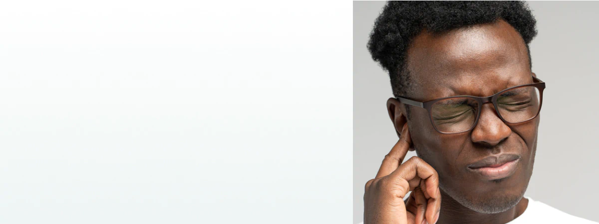 A man pressing his finger to his ear in discomfort, representing the need for supplements for hearing loss.