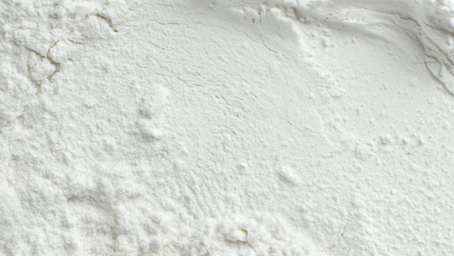 A close-up image showing the fine, granular texture of white L-cysteine powder.