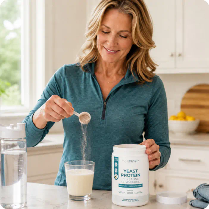 Woman scooping Yeast Protein + Creatine + Hydration into a glass